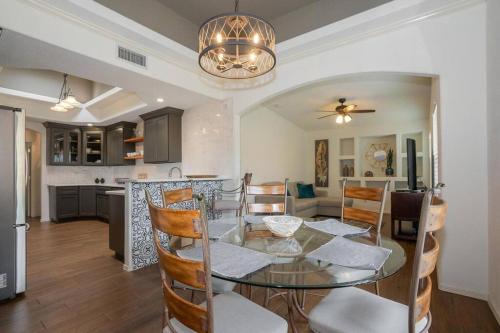 a dining room and kitchen with a glass table and chairs at Amazing home with custom-built pool in El Paso