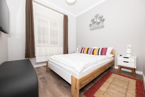 a white bedroom with a bed and a window at Like Home in Oradea