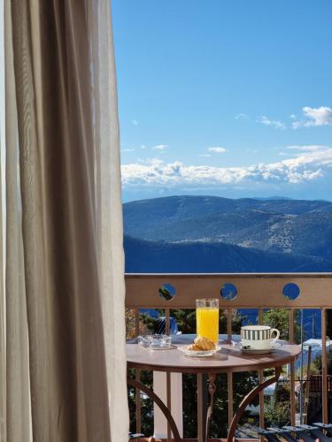 a table with two glasses of orange juice on a balcony at Likoria Hotel in Arachova