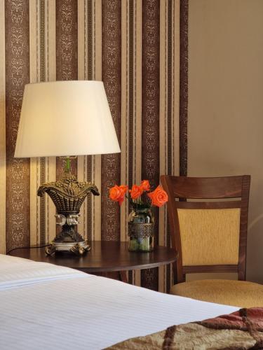 a lamp on a table next to a bed at Likoria Hotel in Arachova