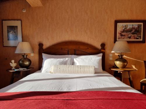 a bedroom with a large bed with two lamps at Likoria Hotel in Arachova