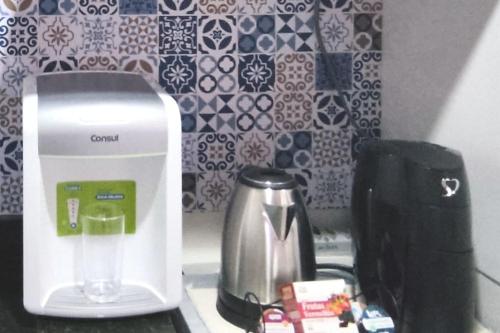 a kitchen counter with a blender and a tea kettle at Flat no Crystal Place, a 6 min do Flamboyant in Goiânia