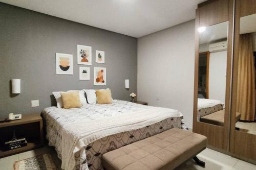 1 dormitorio con 1 cama grande y espejo en Ap Ipê um quarto no Crystal Place, en Goiânia