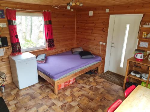1 dormitorio con 1 cama en una cabaña de madera en Toma pirts MAZĀ, en Ikšķile