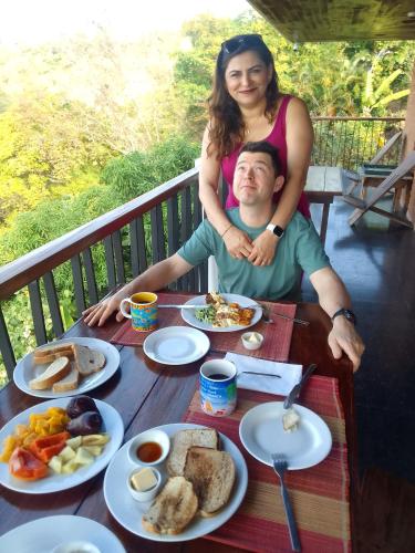 a man and a woman sitting at a table with food at Tranquility Estate in Kingston