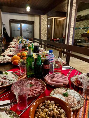 a long table with plates of food and drinks at Къща за гости Александра in Dobrinishte