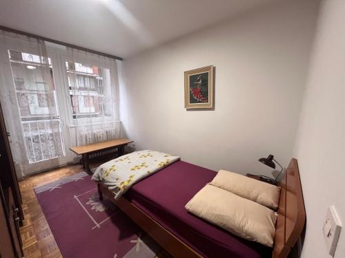 a small bedroom with a bed and a window at Apartment Ciglane - Pet friendly in Sarajevo