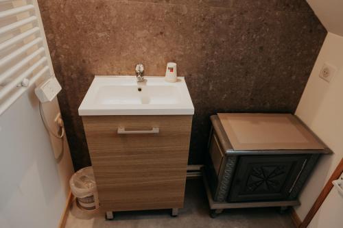 a small bathroom with a sink and a trash can at L'ancienne forge 3 chambres d'hôtes à l'étage la forge , l'enclume et le marteau est petite conseillé pour 1 à 2 nuits une petite chambre in Louvetot