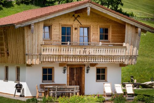 a log cabin with a deck and a table and chairs at Ettlerlehen Chalets in Ramsau