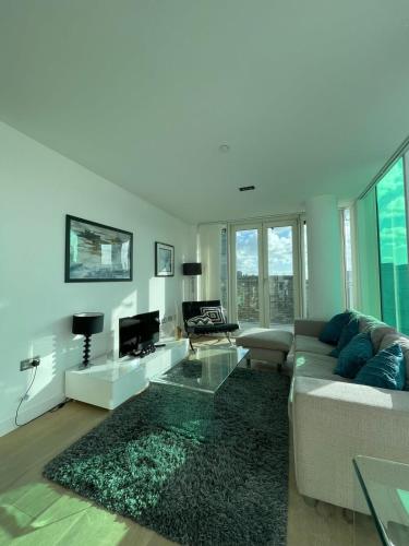 a living room with a couch and a tv at Exquisite 2BD Flat w Balcony Shoreditch! in London