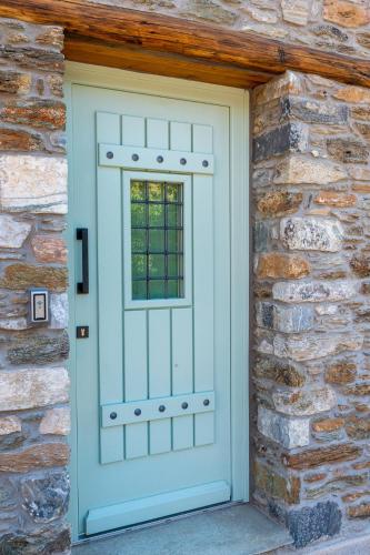 a door on a stone wall with a window at Nostos Country House in Tsagarada