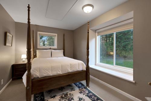 a bedroom with a bed and a window at Las Casas Feliciano - Lummi Island in Lummi Island