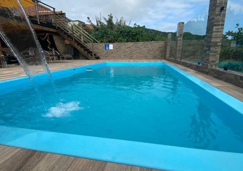 a swimming pool with a water fountain at Pousada São Miguel Beach Beira Mar in Penha