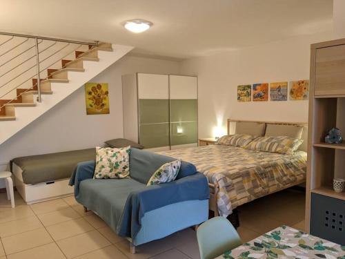 a bedroom with a bed and a couch and a staircase at I Girasoli in Montegrotto Terme