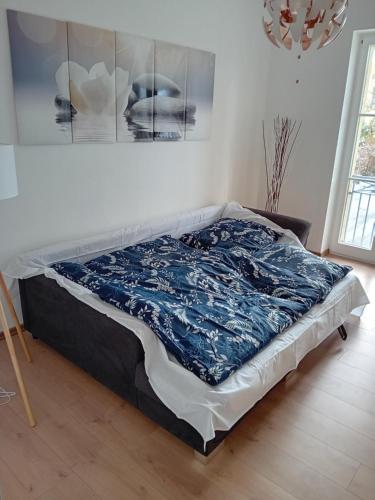 Una cama en una habitación con una manta azul. en Top Ferienwohnung in sehr guter Lage en Dresden