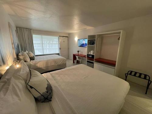 pokój hotelowy z 2 łóżkami i telewizorem w obiekcie Cozy hotel with Super location near Disney w mieście Kissimmee