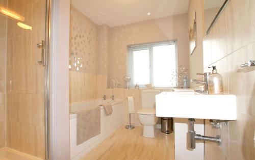 a bathroom with a sink and a tub and a toilet at 2 Friends Close in Kent