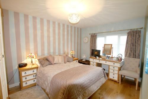 a bedroom with a bed and a dresser and a mirror at 2 Friends Close in Kent