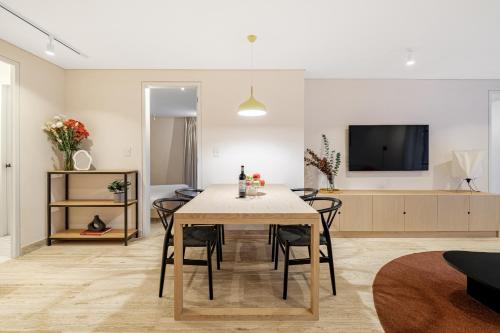 a dining room with a table with chairs and a tv at Nido Condesa in Mexico City