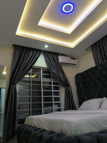 a bedroom with a bed and a ceiling with a window at JKA 2-BEDROOM-Apt 24HRS POWER Unlimited WIFI , GARDEN PATIO AREA,FREE DAILY HOUSEKEEPING in Lagos