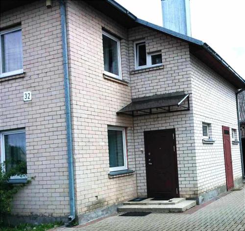 a large brick building with a door and a street at Town House in Kėdainiai