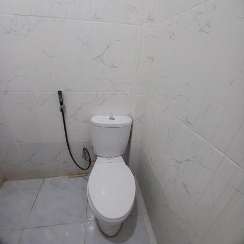 a bathroom with a white toilet in a room at Bumi Homestay in Painan