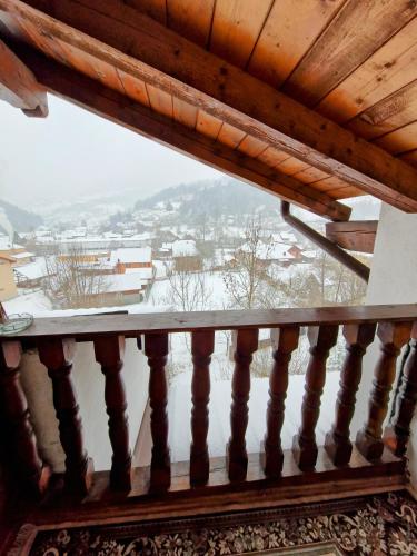 a balcony with a view of a snow covered city at Pensiunea Jianu in Albac
