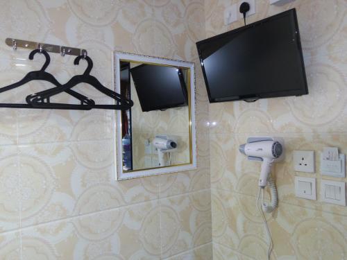 uma casa de banho com uma televisão, um espelho e uma câmara em Mabuhay Hotel em Hong Kong