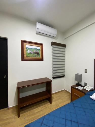 um quarto com uma cama, uma secretária e uma janela em Hotel&Salón RG em Tlapacoyan