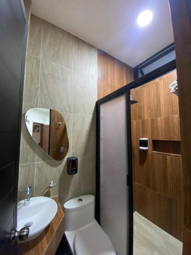 uma casa de banho com um WC, um lavatório e um espelho. em Hotel&Salón RG em Tlapacoyan
