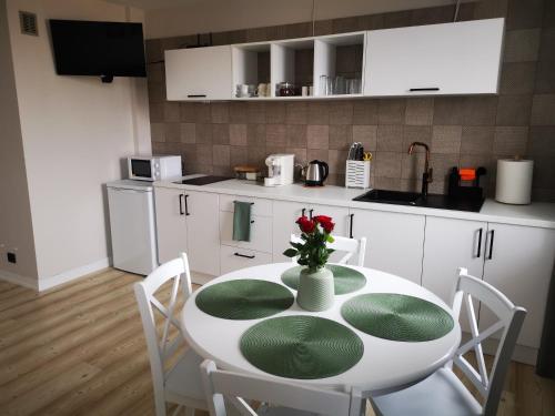 a kitchen with a white table with a vase of flowers on it at Czwarte Piętro in Zamość