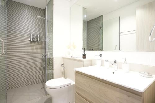 a bathroom with a toilet and a sink and a shower at Cozy Flat in Business Bay in Dubai