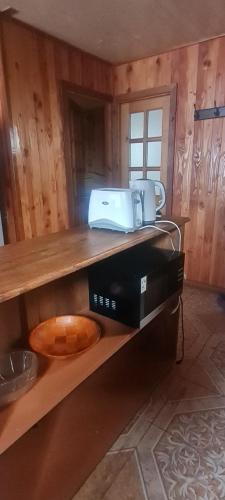 a kitchen with a microwave on a wooden shelf at cabaña pucón in Pucón