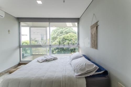 un grande letto in una stanza con una grande finestra di Luxury, Bbq & Pool In Villa Morra ad Asunción
