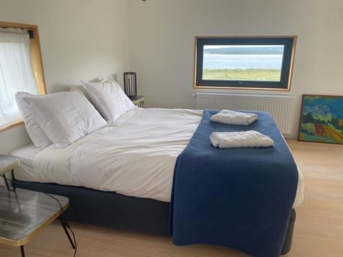 sypialnia z dużym łóżkiem z dwoma ręcznikami w obiekcie Look Out - Loft w mieście Puerto Natales