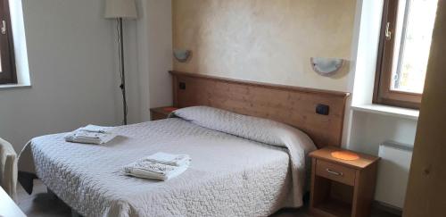 a bedroom with a bed with two towels on it at Le Bottesele in San Zeno di Montagna