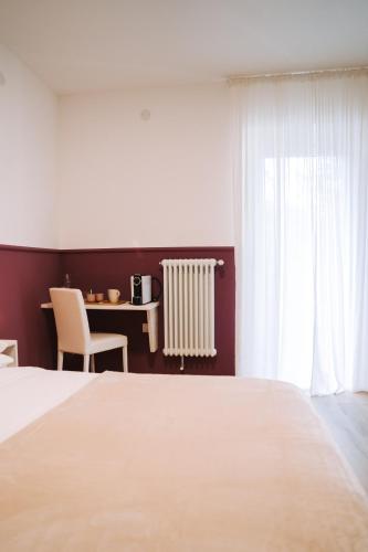 a bedroom with a white bed and a window at Casa Camilla in San Michele allʼAdige