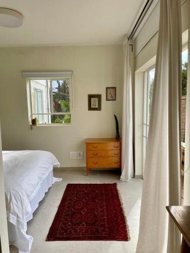 a bedroom with a bed and a window and a rug at בקתות האס ואטינגר in Jaba‘