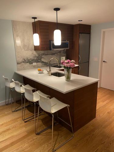 a kitchen with a kitchen island with chairs and a sink at Cozy Garden Apt in Williamsburg NYC Townhouse in Brooklyn