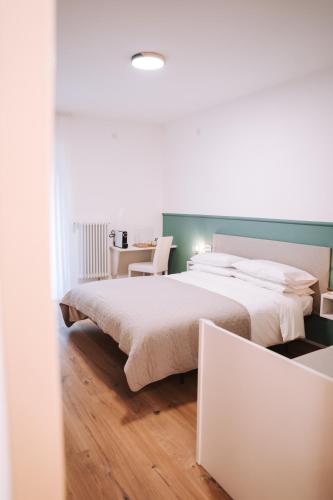 ein Schlafzimmer mit einem großen Bett und einem Tisch in der Unterkunft Casa Camilla in St. Michael an der Etsch