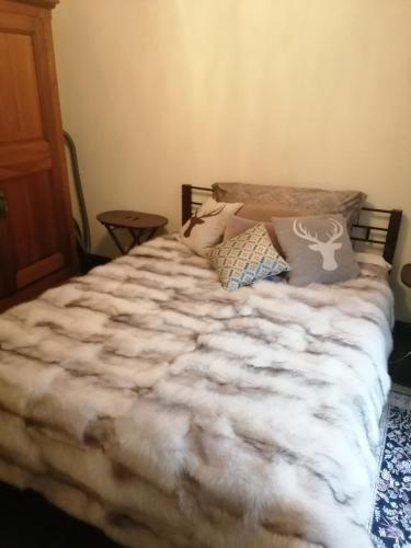 a bedroom with a bed with a white comforter at Magnifique Appartement Cosy in Chateau-d'Oex