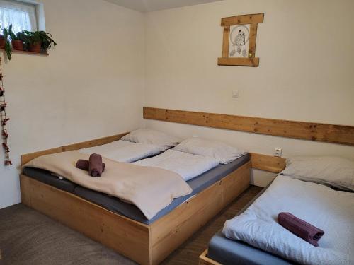 two twin beds in a room with a clock on the wall at Chalupa M&P 2 in Ružomberok