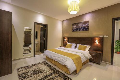 a bedroom with a large bed and a bathroom at Al Itqan For Serviced Apartments-الاتقان للشقق المخدومة in Jeddah