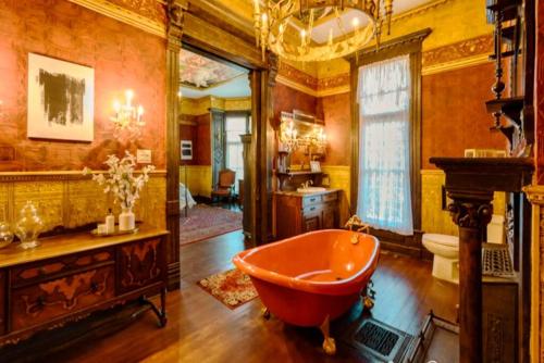 uma casa de banho com uma banheira vermelha num quarto em Historical Mansion - Braun Manor em Denison