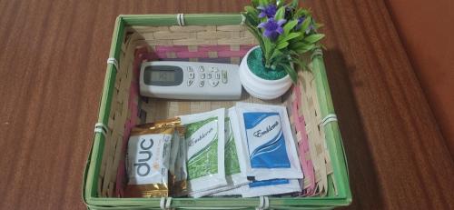 a basket with a remote control a calculator and flowers at Alojamiento en pleno centro de Corrientes in Corrientes