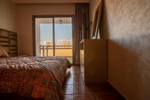a bedroom with a bed and a view of a balcony at Luxury Apartment with Pool in Agadir Bay 5 Min Walk to Beach in Agadir