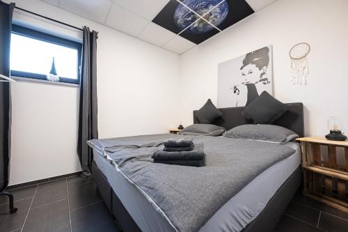 una camera da letto con un grande letto con un orologio sul muro di Wohnwerk Studio Petrisberg a Treviri
