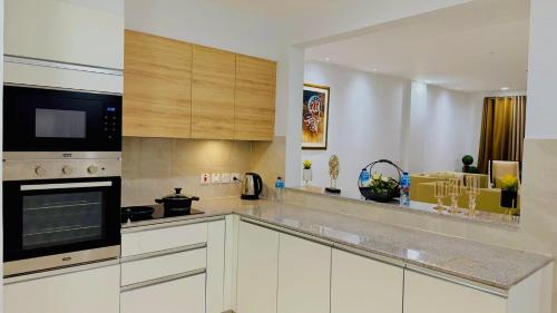 a kitchen with white cabinets and a stove top oven at Premium&Cozy One Bed DHA LHR in Lahore