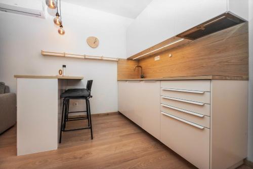 uma cozinha com um balcão e um banco em City Center Apartment - Modern & Elegant em Bratislava