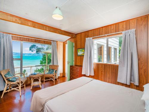 Un pat sau paturi într-o cameră la Waters Edge Cottage - Hahei Bach